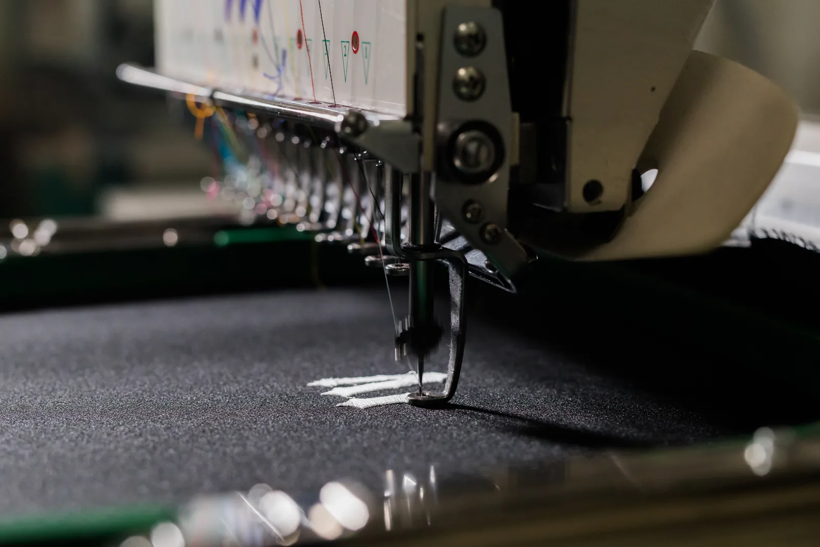 Machine detail work being applied to dark fabric