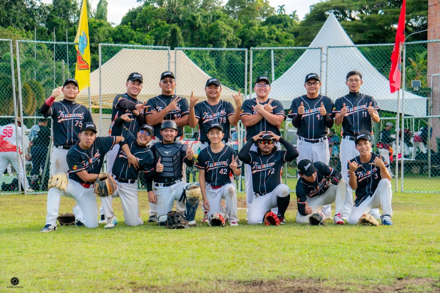 Baseball team wearing coordinated black jerseys, white trousers and caps